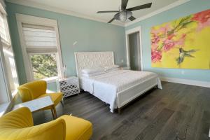 纳瓦拉Holley Point Holiday House的卧室配有一张床,墙上挂有绘画作品