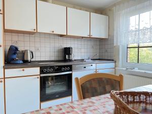 维斯莫尔Ferienhaus Wieke的厨房配有白色橱柜和烤箱。