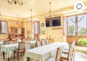 扎费拉纳-埃特内阿安蒂科博尔戈佩特拉利亚酒店的一间带桌椅和电视的用餐室