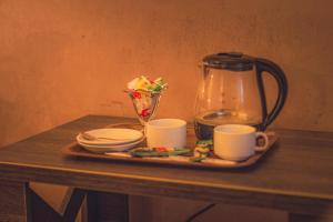 巴库Passage Art Hotel的盘子,盘子上放着咖啡壶和杯子