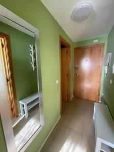 布拉内斯Apartamento MARINA PLAYA, primera linea de mar的绿色的客房设有镜子和木门