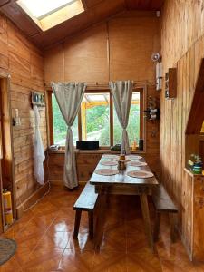 El EncanoCASA LA KOCHA, Cabin, Hostal en la Laguna de la Cocha的小屋内带木桌的用餐室