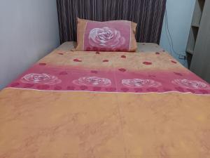马尼拉Toledo Jungle, Tropicana Garden City, Sumulong Highway, Marikina City, 1800的一张带粉红色毯子和粉红色枕头的床