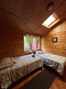 El EncanoCASA LA KOCHA, Cabin, Hostal en la Laguna de la Cocha的小木屋内的两张床,设有窗户