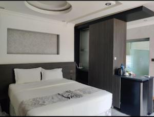 蒙巴萨Charchoma Restaurant的卧室设有一张白色大床和一扇窗户。