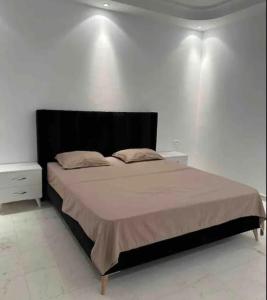 突尼斯Appartement haut standing 170 m2的一间卧室配有一张大床和黑色床头板