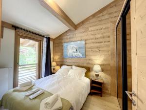 莱热STELLA - Les Gets - Centre village的卧室配有白色的床和木墙