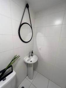 圣保罗Confortavel apartamento em SP的白色的浴室设有水槽和镜子