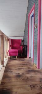 波德古任Ostoja Karkonoska的客厅铺有木地板,配有粉红色的沙发