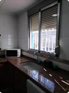 Mareny BarraquetasLa Caseta de Jose的带水槽的厨房台面和窗户