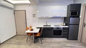 雅典FlatG 23的厨房配有黑白电器和桌子