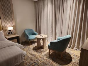 乌姆莱季SEAGULL HOTEl的酒店客房配有一张床、两把椅子和一张桌子