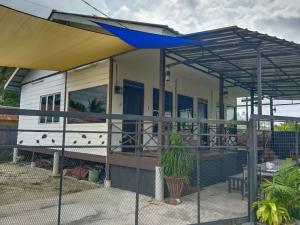 甲抛峇底Rods Homestay - Kg Agong Penaga的门廊上带遮阳篷的 ⁇ 