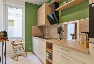 什未林Schelfstadtoase的厨房设有绿色的墙壁和带椅子的柜台。
