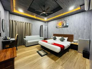 古瓦哈提N.K. Residency的一间卧室配有一张床、一张桌子和一把椅子