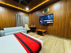 古瓦哈提N.K. Residency的一间卧室配有一张床和一台平面电视