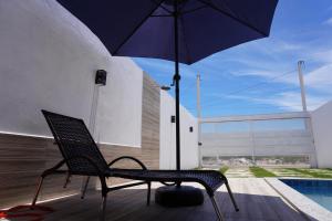 普拉杜ESTRELA DO MAR的游泳池畔的一把带遮阳伞的椅子