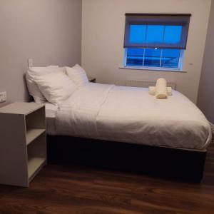 基尔肯尼Parliament Inn的一间卧室配有一张带白色床单的床和一扇窗户。