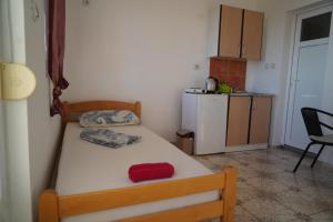 多布拉沃达Apartments Safija的一间带床的小卧室和一间小厨房