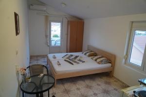 多布拉沃达Apartments Safija的卧室配有床、椅子和窗户。