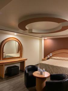墨西哥城Hotel Gran Vía的酒店客房,配有床和镜子