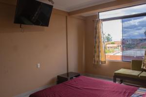 塔里哈Residencial Tablada的一间卧室设有一张床、一台电视和一个窗口。
