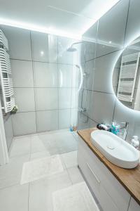 华沙Apartamenty Bokserska的白色的浴室设有水槽和淋浴。