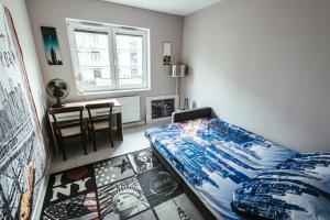华沙Apartamenty Bokserska的一间卧室配有一张床、一张桌子和一个窗户。