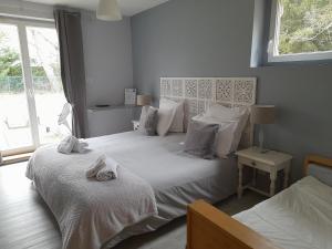 Saulcy-sur-MeurtheL'AMANDAURE的一间卧室设有两张带白色床单的床和窗户。
