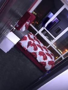 迪拜Paz Holiday Luxurious Space的窗户上一张铺有红白床单的床