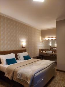 里贝朗普雷托Hotel Pousada Santa Rita的一间卧室配有一张大床和两个蓝色枕头