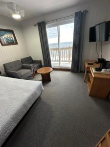滨海卡尔顿卡尔顿瑟迈汽车旅馆的酒店客房配有一张床、一张沙发和一张书桌。