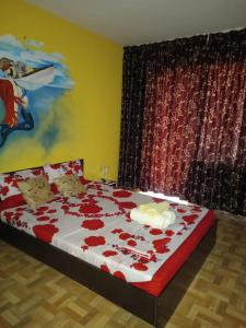 北马马亚-讷沃达里EL Capitano - Mamaia Nord的一间卧室,床上有红色玫瑰