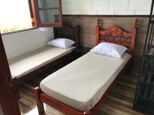 卡拉瓜塔图巴Villaggio Miravela的带窗户的客房内设有两张单人床。