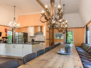 德布尔特Designed home with bedstead, surrounded by forest的用餐室以及带木桌和吊灯的厨房。