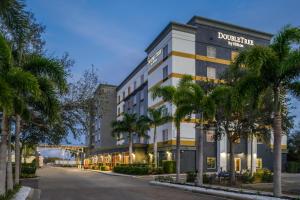 萨拉索塔DoubleTree by Hilton Sarasota Bradenton Airport的街道前方有棕榈树的建筑