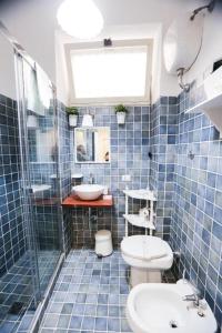 那不勒斯Chiaia Bridge B&B的蓝色瓷砖浴室设有卫生间和水槽