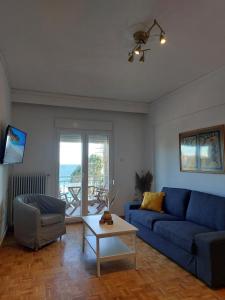 卡瓦拉Nicola's House - Palio的客厅配有蓝色的沙发和桌子