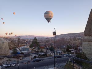 格雷梅Turan Cappadocia Cave的一群热气球飞越城市