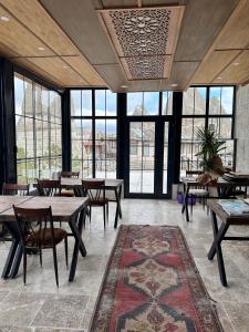 格雷梅Turan Cappadocia Cave的用餐室设有桌椅和窗户。
