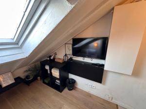巴黎Marais Rooftop Studio - Metro Filles du Calvaire的客厅设有壁挂式平面电视。