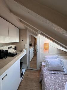 巴黎Marais Rooftop Studio - Metro Filles du Calvaire的一间设有厨房和一张位于客房内的床的房间