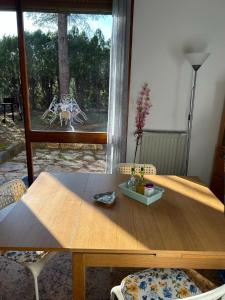 瓦拉泽Casa con giardino: Varazze的窗户客房内的一张带椅子的木桌