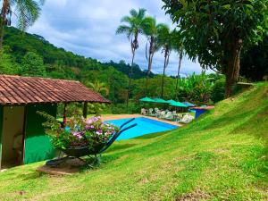 马卡科斯Pousada Recanto do Chalé Ltda的一个带游泳池和棕榈树的度假村