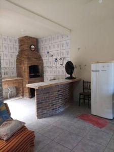 里奥格兰德Casa 6 minutos Praia do Cassino.的厨房设有砖砌壁炉和冰箱。