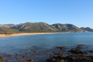 弗卢米尼马焦雷Agriturismo Perdaba的享有海滩美景,背景为群山