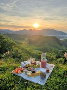 雅库廷加河畔圣丽塔Pousada Iasbeck的山丘上带食物的野餐桌,日落