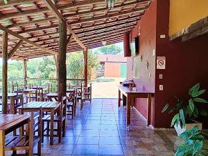 马卡科斯Pousada Recanto do Chalé Ltda的一间空餐厅,配有木桌和椅子