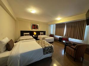 利马埃尔坦博1号酒店的酒店客房设有两张床和一张桌子。