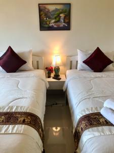 讪巴东Naraya Homestay的客房设有两张床和一张带台灯的书桌。
